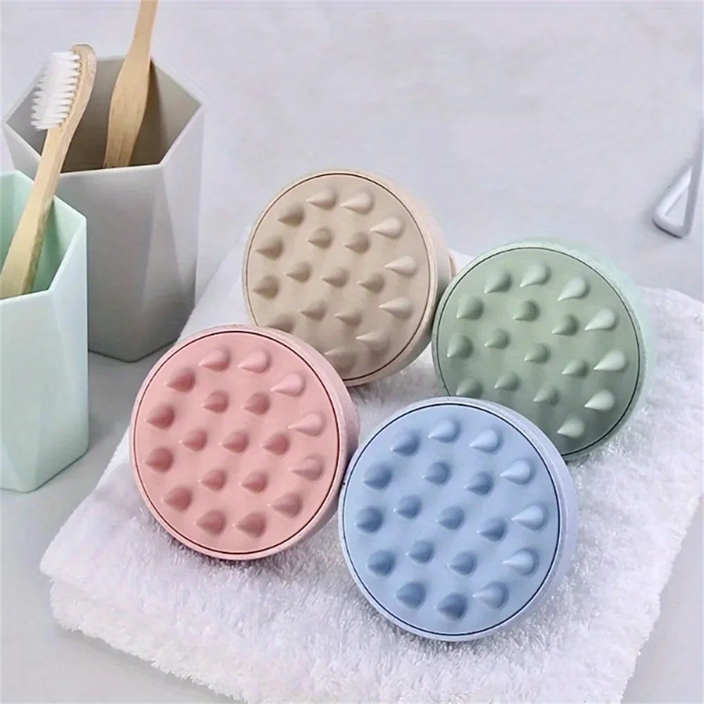 Four round, textured containers in pastel colors on a towel with toothbrushes in the background.