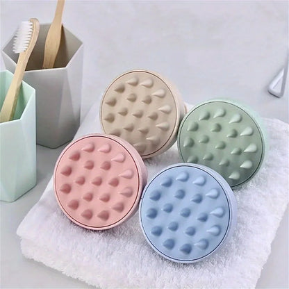 Four round, textured containers in pastel colors on a towel with toothbrushes in the background.