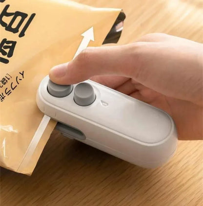 Hand using a white sealing device on a package with Japanese text.