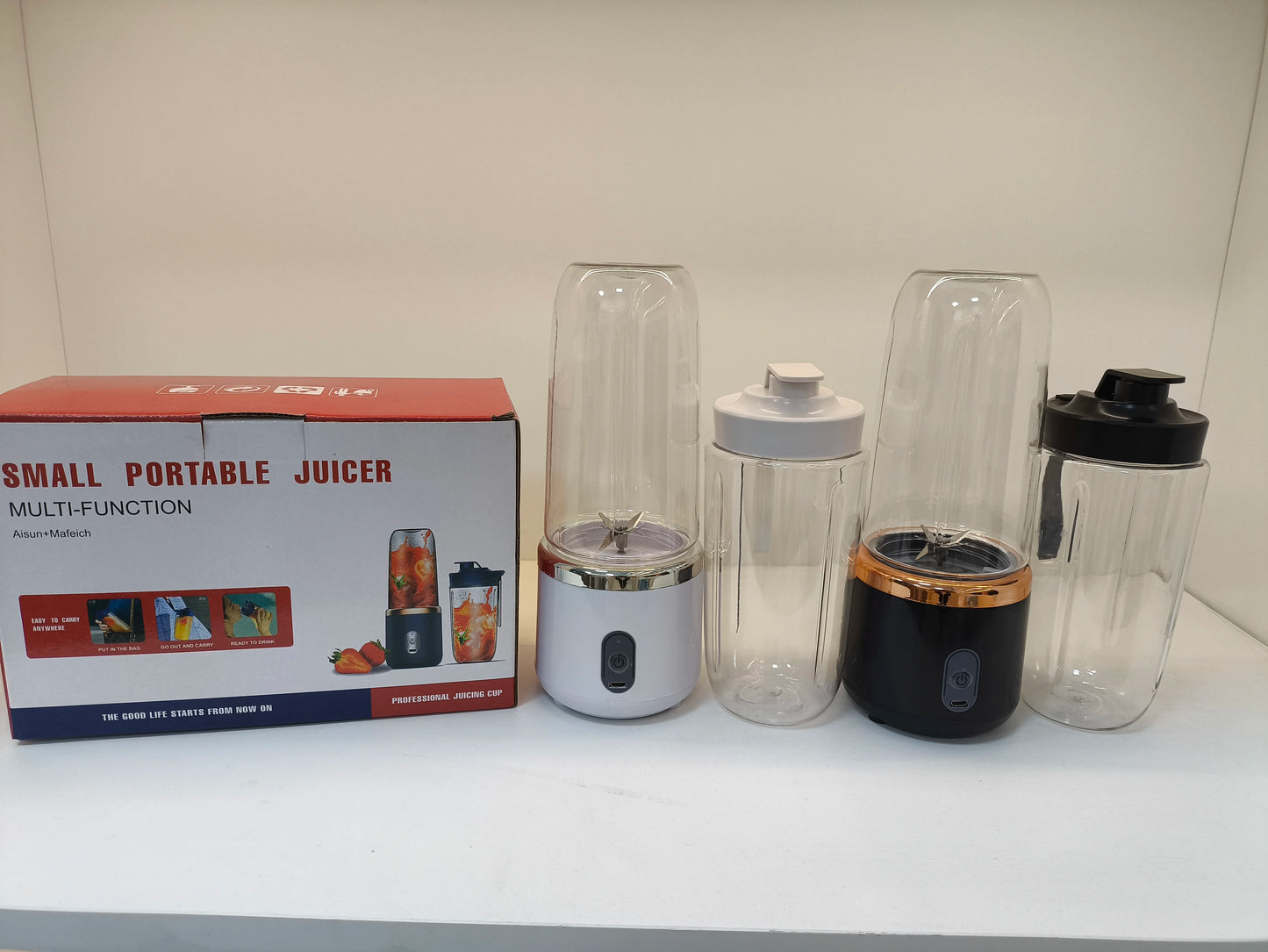 Small portable juicer with packaging on a white surface